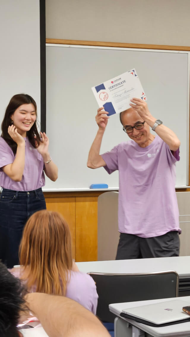 卒業証書を掲げる松岡さん